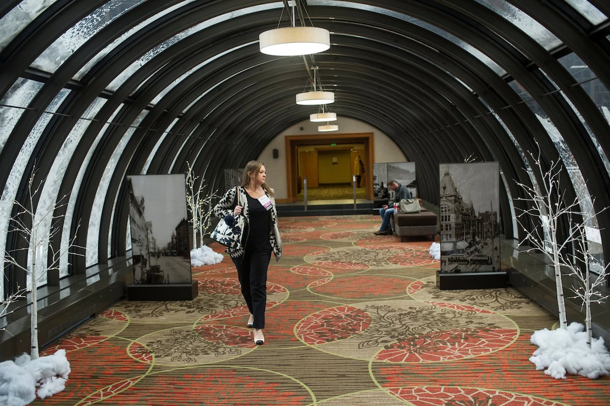 A woman walking through a dimly lit tunnel in a modern building