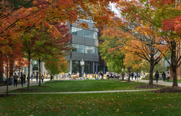 Horizon Hall and the clock on the Fairfax Campus framed by autumn leaves.