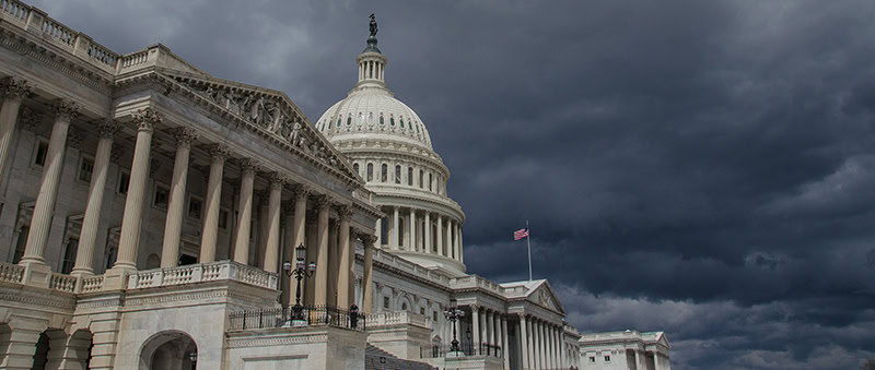 Capitol dome below gray stormy skies