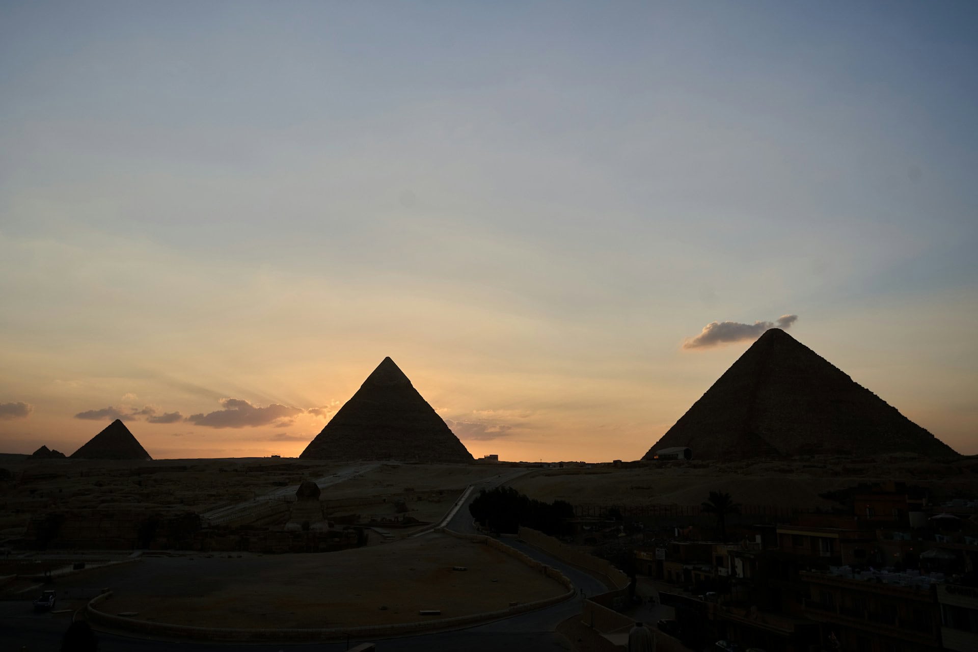 The Pyramids of Giza majestically standing at sunset, showcasing their ancient grandeur and timeless beauty.