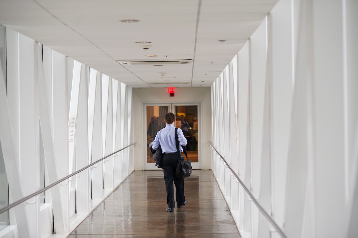 A businessman in a suit walking confidently down a hallway.