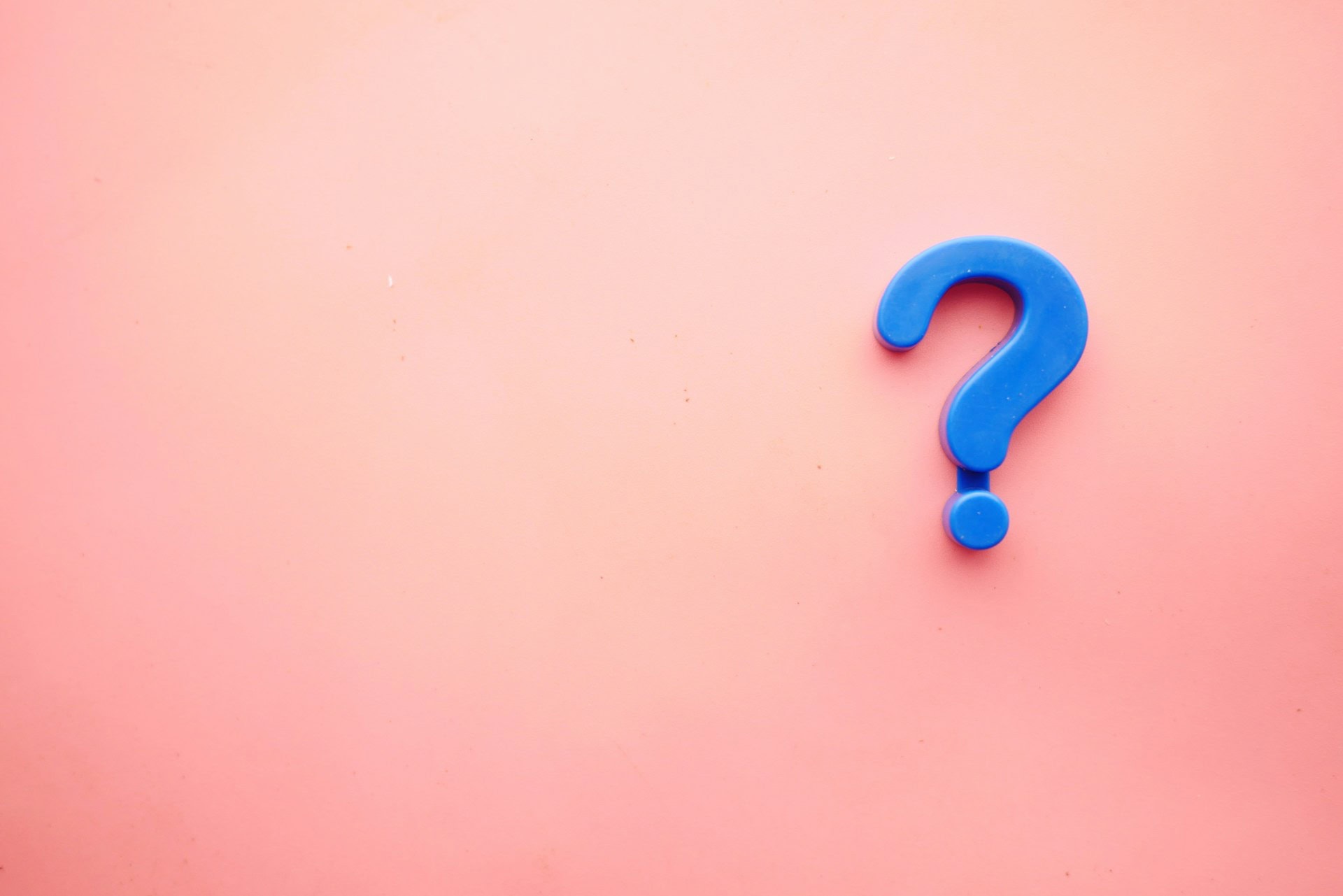 A blue question mark symbol on a pink background.