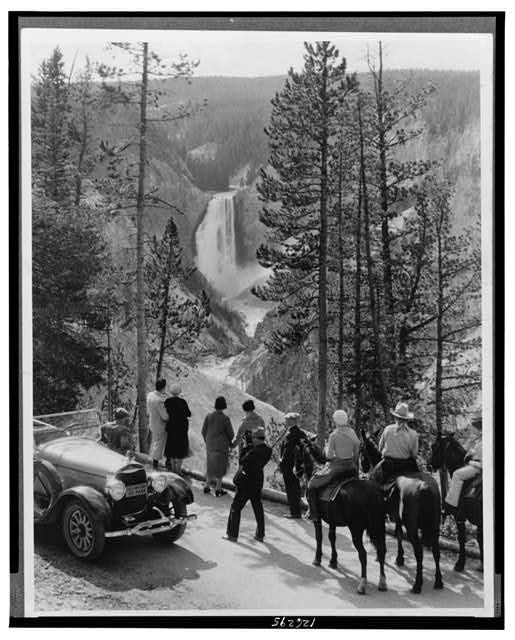 Group of people, some on horseback, looking at canyon and Great Fall of the Yellowstone River, Yellowstone National Park, Wyoming.