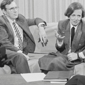 Two people sitting on a couch talking to an interviewer.